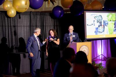 People at a podium sharing a toast